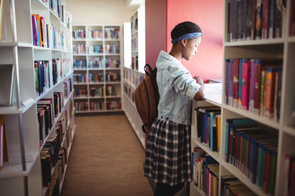 rsz attentive schoolgirl reading book in library c6msdz7