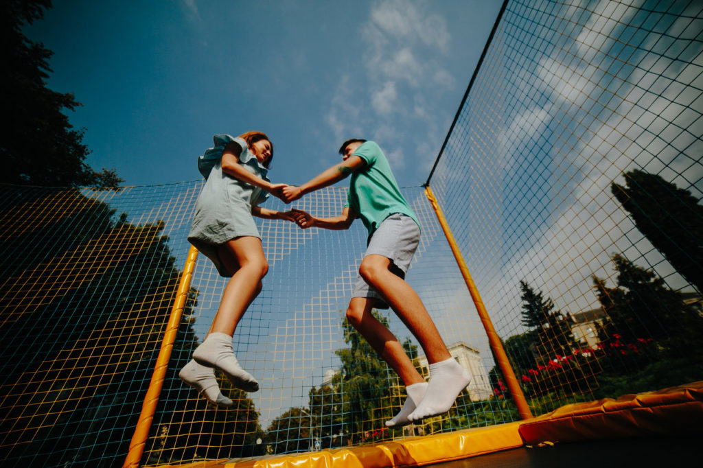 rsz couple jumping on trampoline in the park pkp3f37