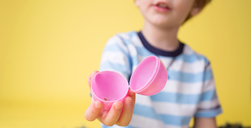 Child holding an empty open plastic easter egg