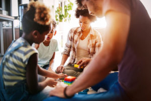 happy black family playing game together at home K9D5BTY scaled e1575413724847